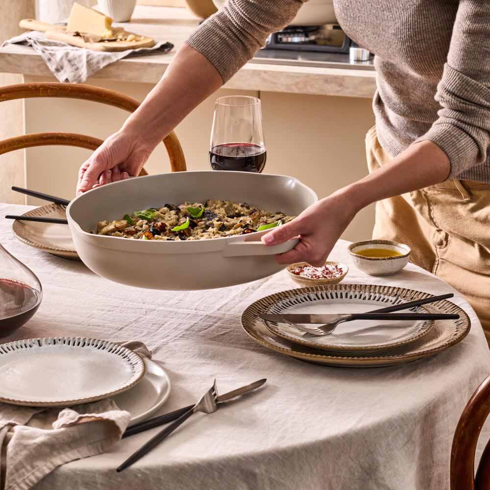 risotto served in a cream saute pan on the dining table