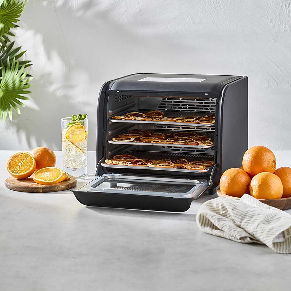 black dehydrator wth racks of orange slices