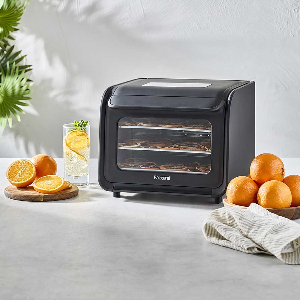 black dehydrator wth racks of orange slices