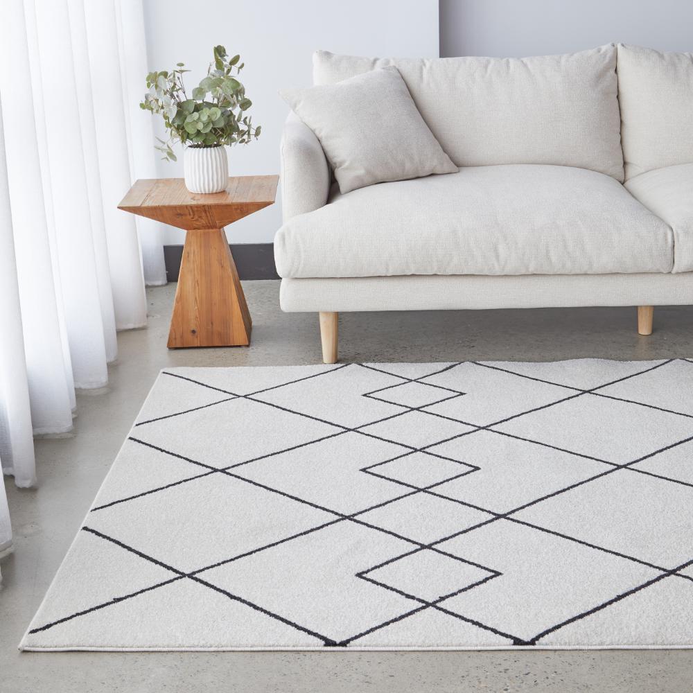grey abstract rug with cream lounge and wooden side table - House