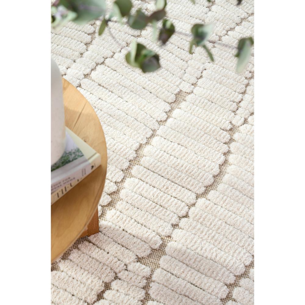 Natural beige waves rug with side table, books and vase - House