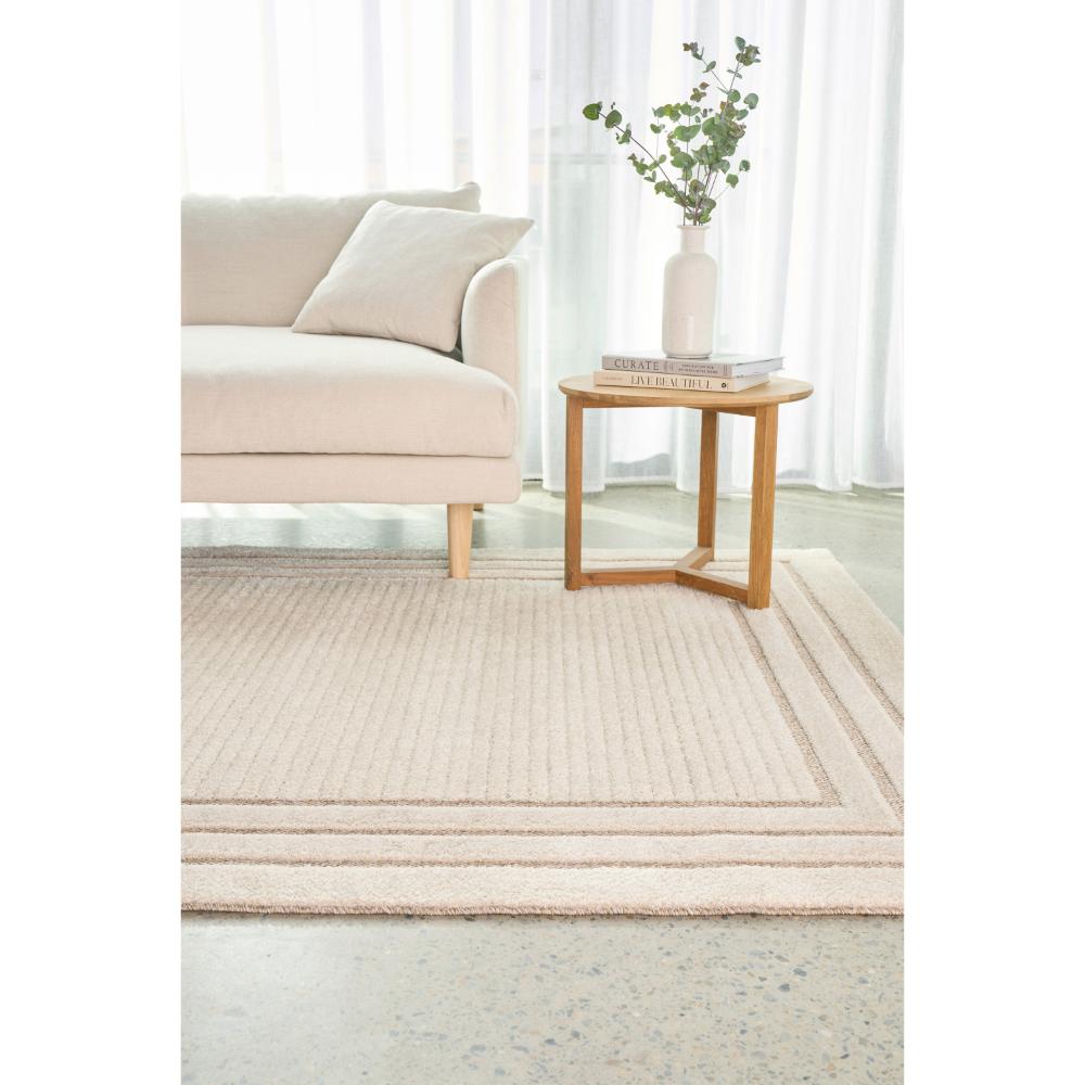 cream beige rug with triple border with lounge and table - House