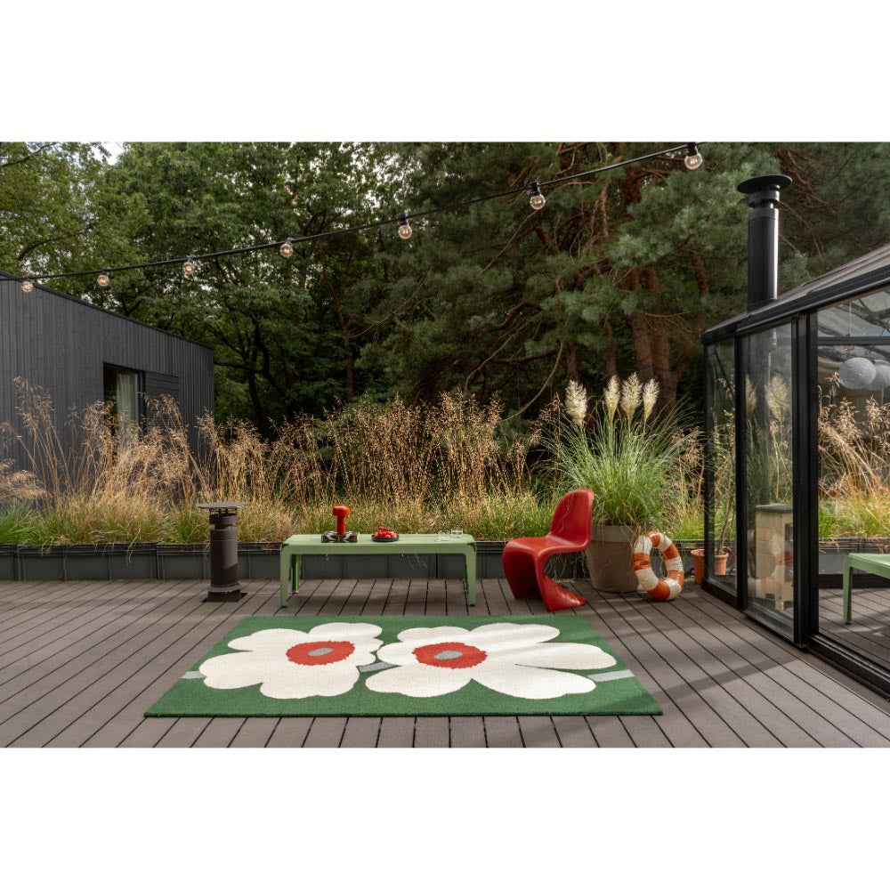 Marimekko Unikko 60th Anniversary Rug Green. Green rug with two large white flowers on a patio