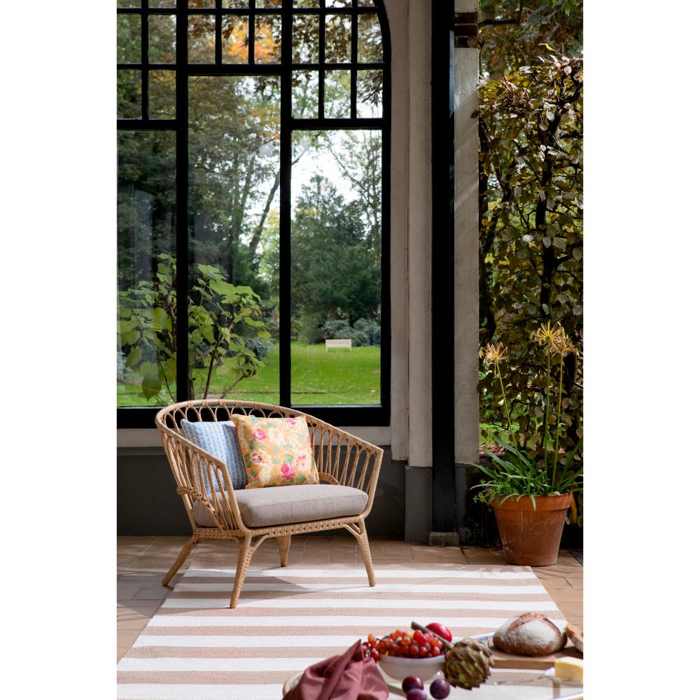 beige and white striped rug in sunroom with armchair - House