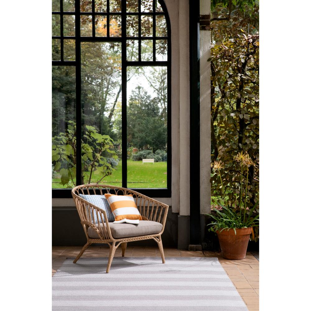 grey and white striped rug in sunroom with armchair - House