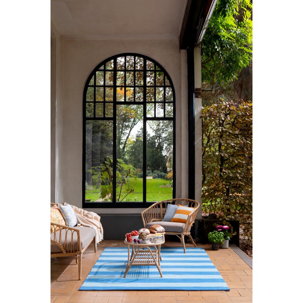 blue striped rug in sunroom with armchair - House