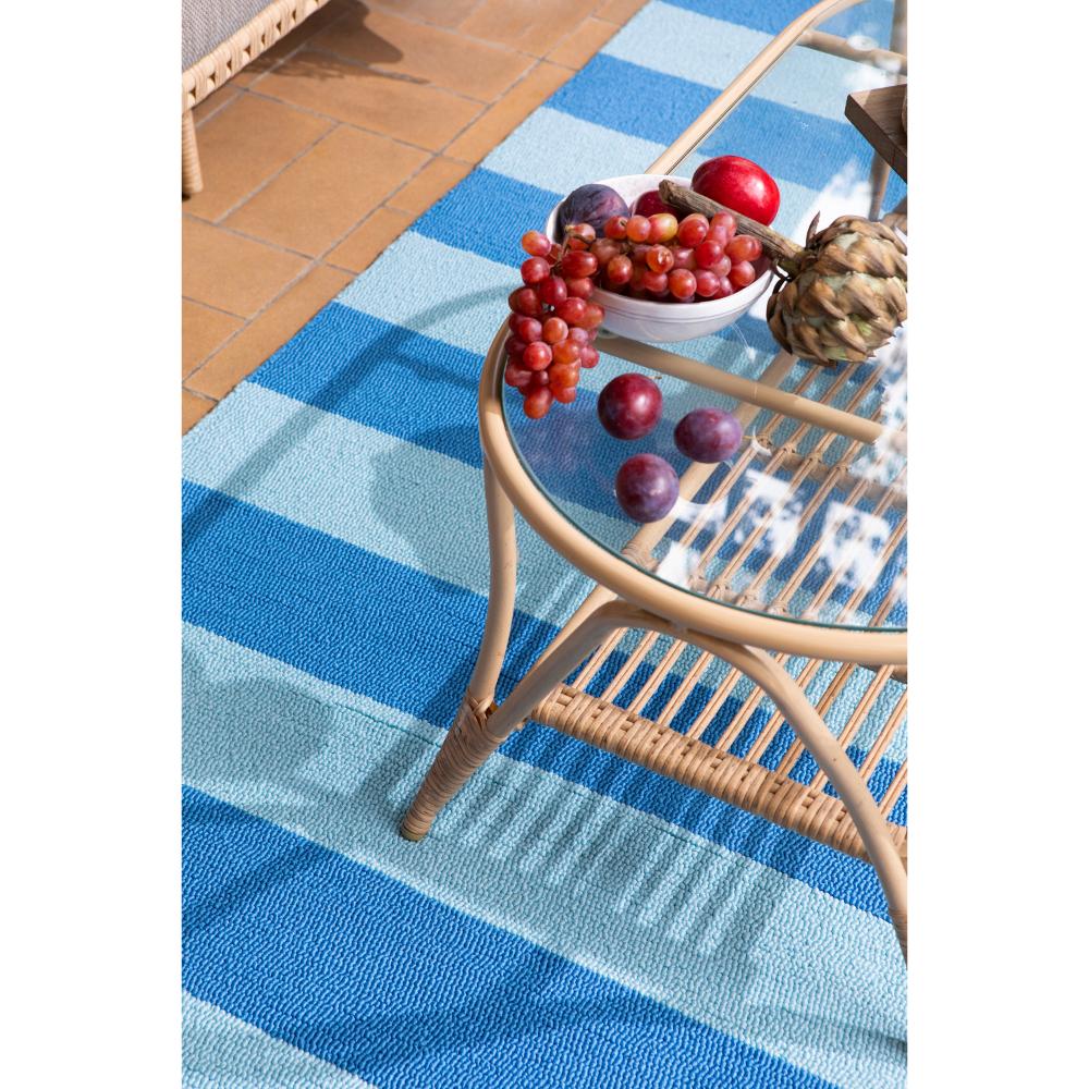 blue striped rug under coffee table with fruit - House