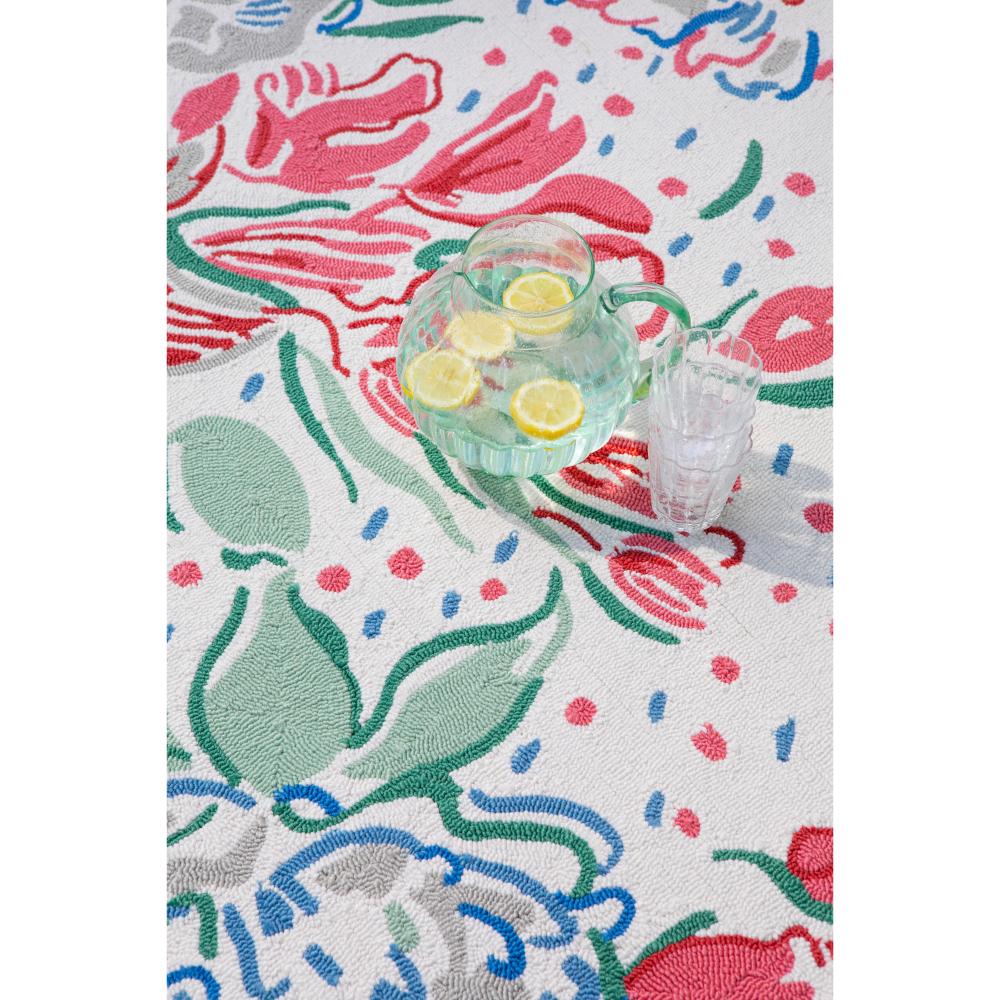 floral indoor/outdoor rug with a jug of water and lemon - House
