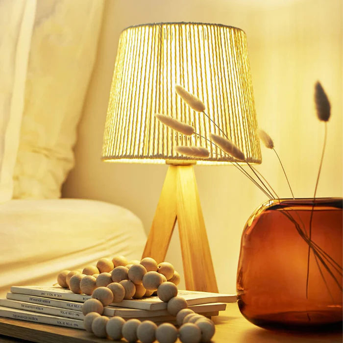 Lamp on a bedside table with books and decorative items, warm lighting