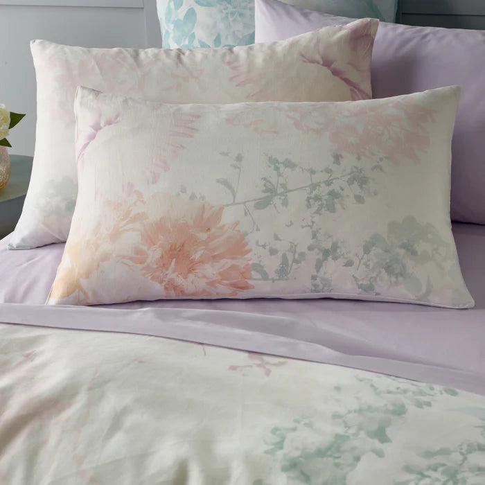 Floral patterned pillow on a bed with matching bedding