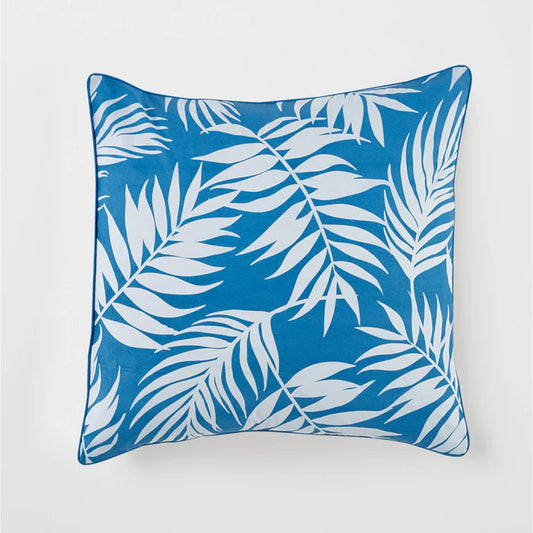 Blue pillow with white leaf pattern on a light gray background