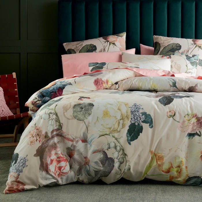 Floral bedding set on a bed with a dark green headboard.