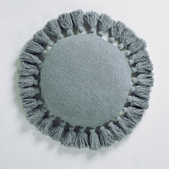Round cushion with tassels on a white background