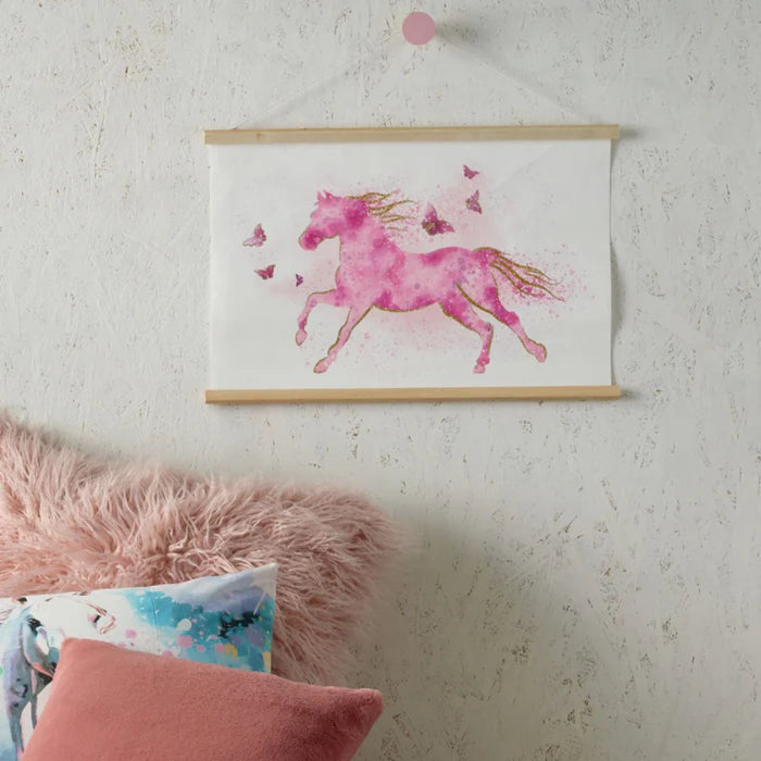 Pink unicorn illustration on a white wall with pink pillows below.