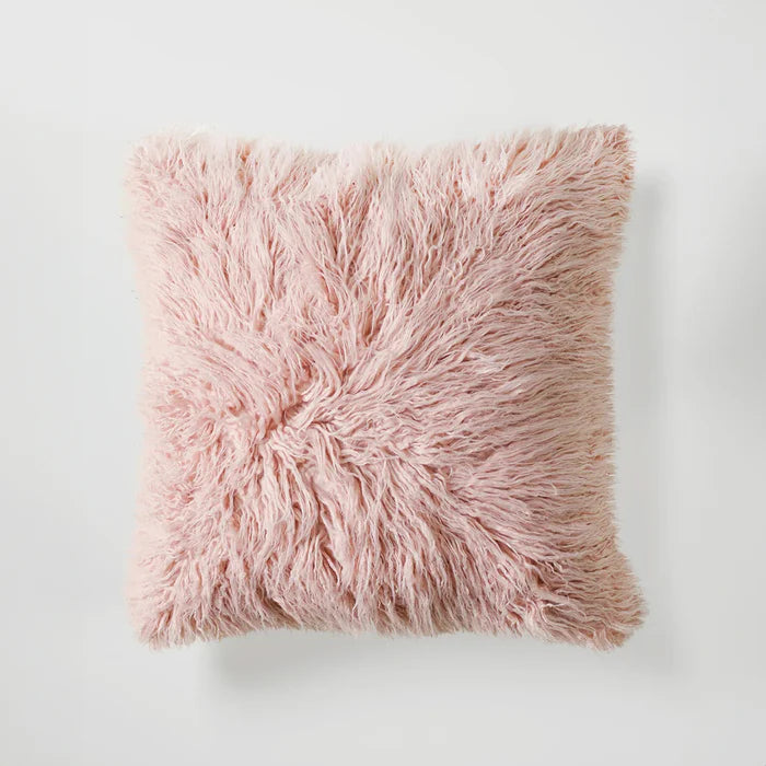 Pink fluffy pillow on a light gray background
