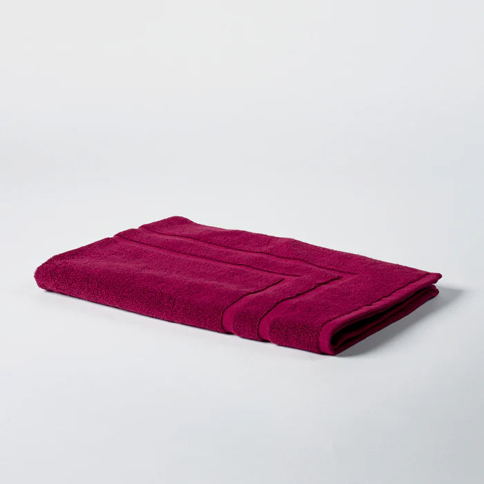 Folded burgundy mat on a light background