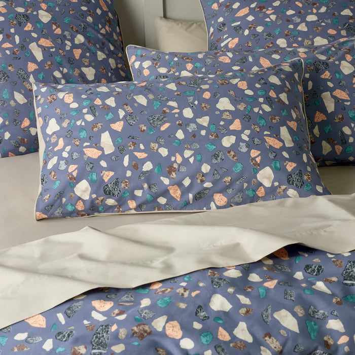 Patterned pillowcases on a bed with a neutral background