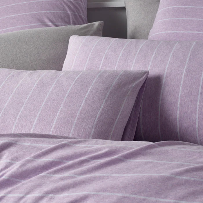 Close-up of purple striped bedding with pillows