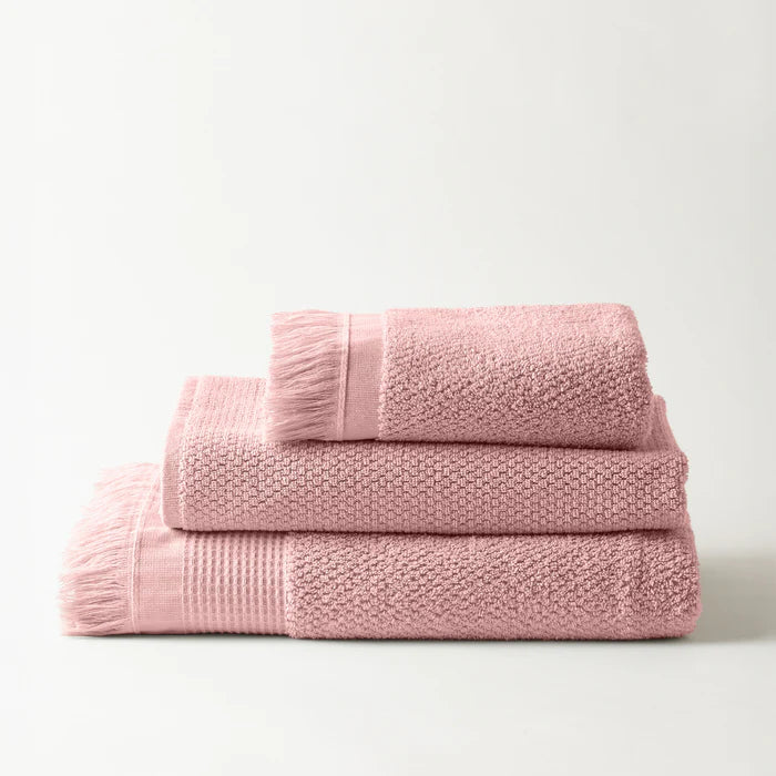 Set of pink textured towels on a light gray background