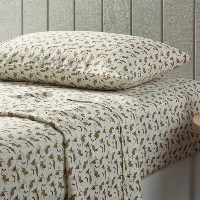 Patterned bed sheets and pillow on a bed with a neutral background