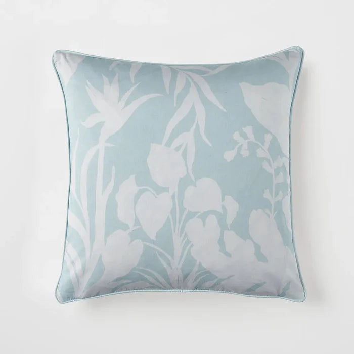 Decorative pillow with white floral pattern on a light blue background