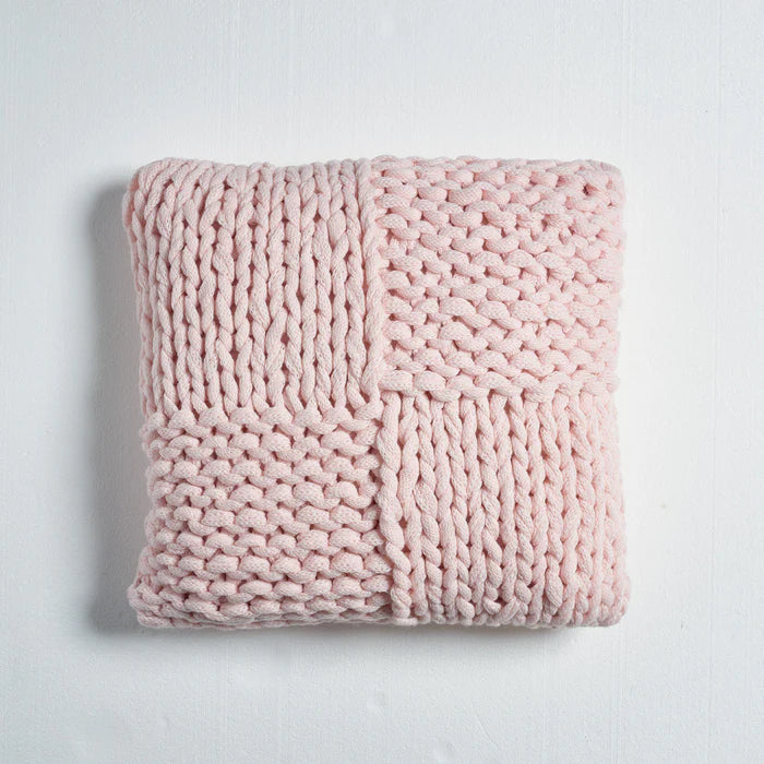 Pink knitted blanket on a light gray background