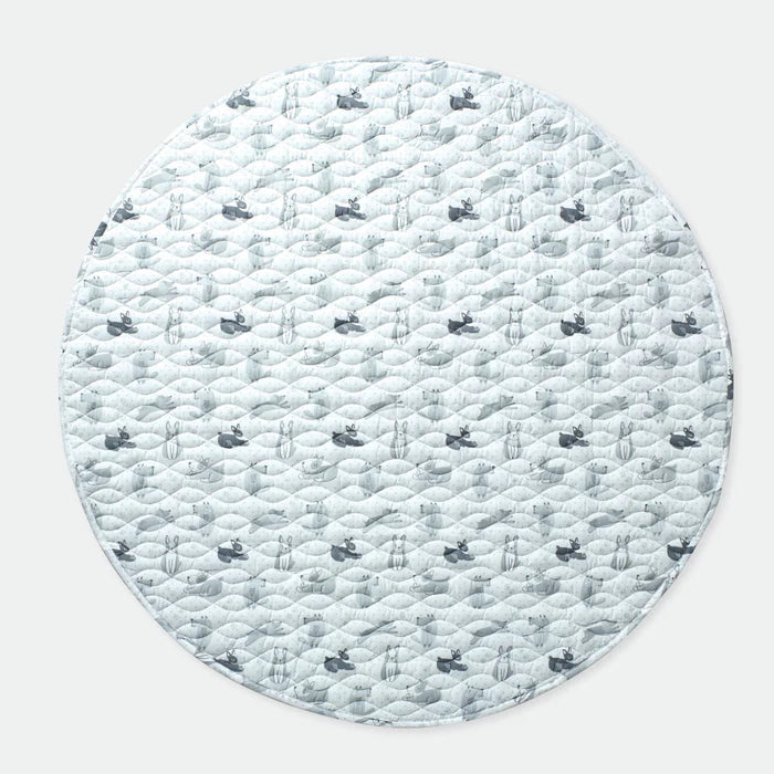 Round quilted mat with a winter scene pattern on a light gray background