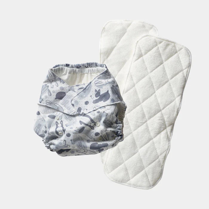 Patterned diaper and quilted pad on a light gray background