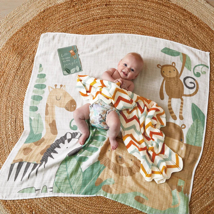 Baby lying on a play mat with animal designs and a chevron blanket
