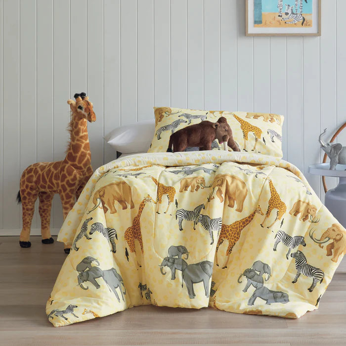 Children's bedding set with animal patterns on a bed in a room.