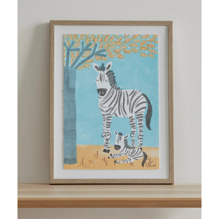 Framed artwork of a zebra and baby zebra under a tree on a wall.