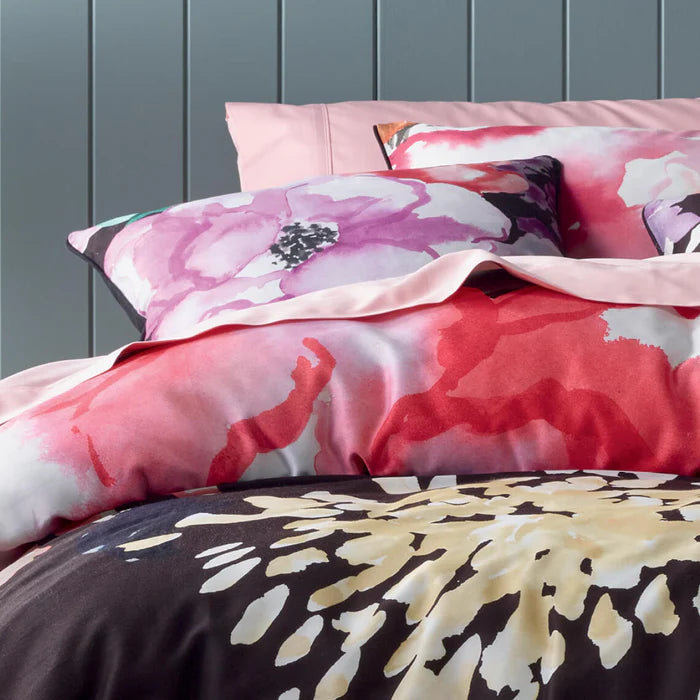 Floral patterned bedding set on a bed with a gray wall background